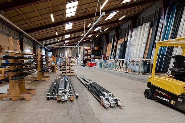 Medarbejder måler glas op i Bygshops produktion i Ringsted